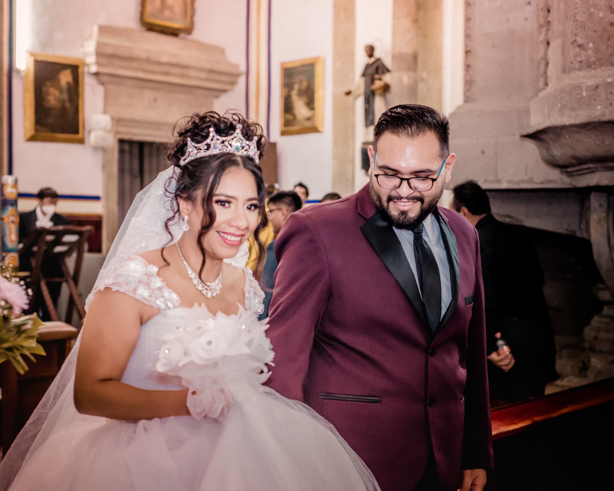 Novios tomados de la mano frente al altar de la iglesia
