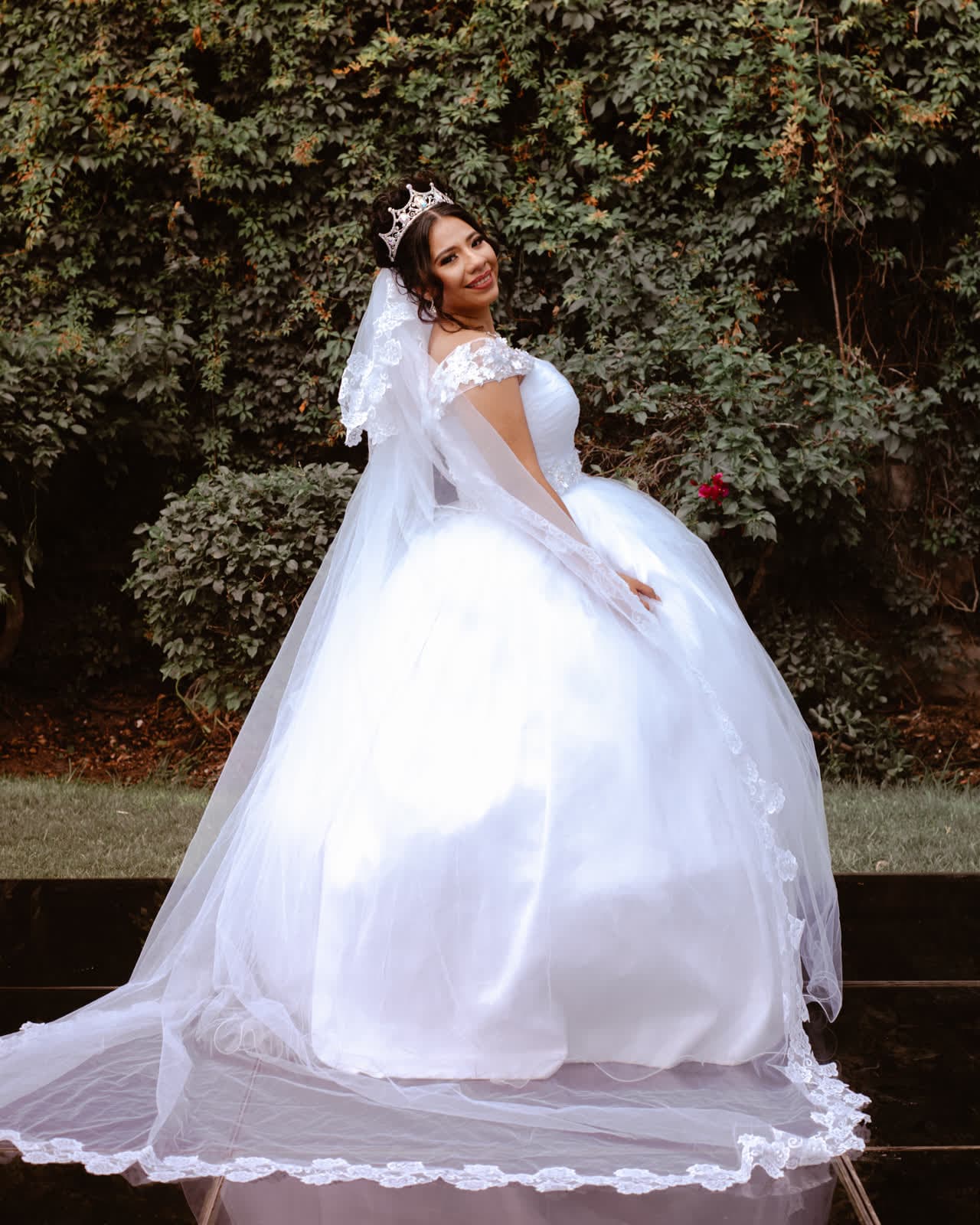 Novia con vestido de cola en el jardín