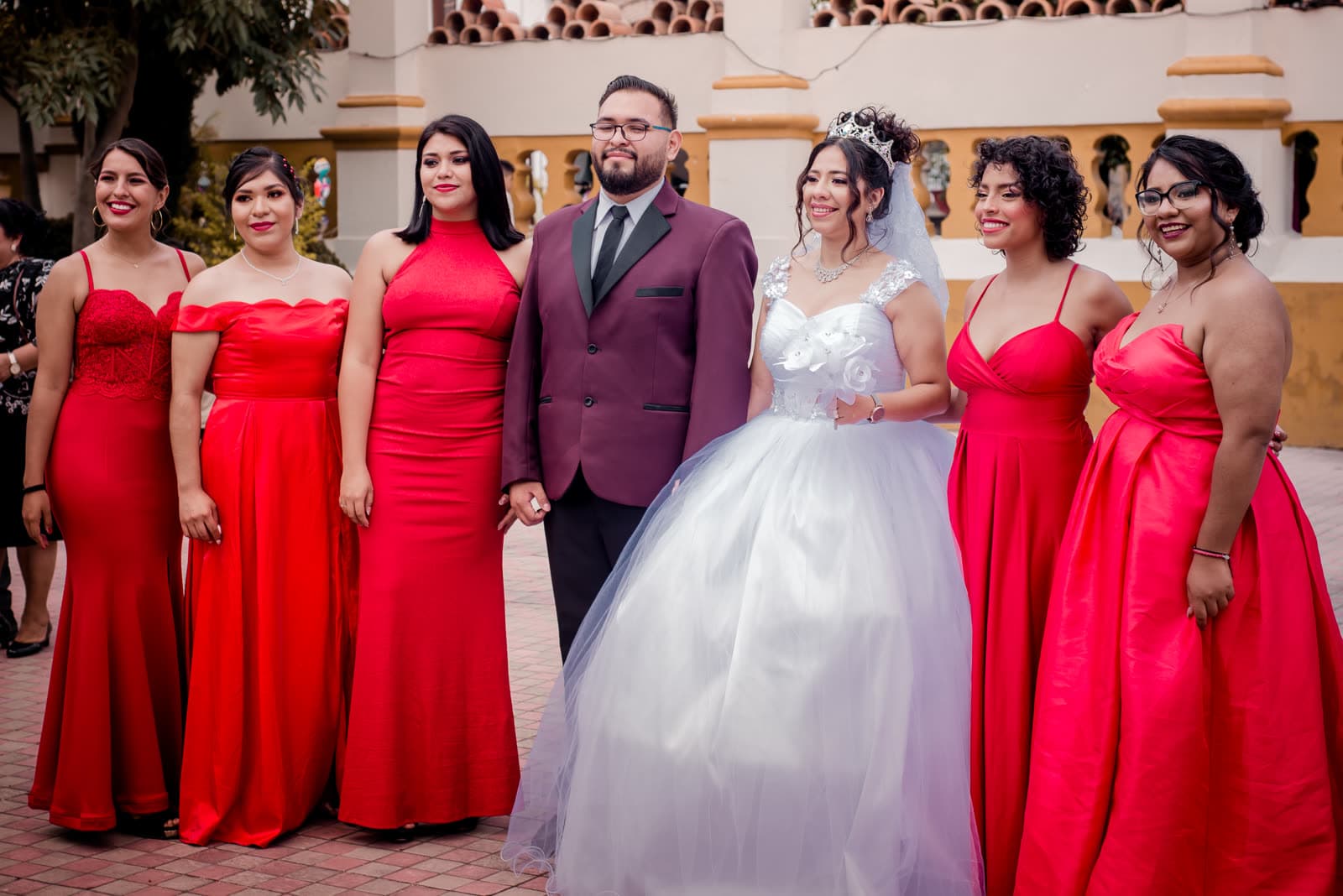 Novia con damas de honor en vestido rojo