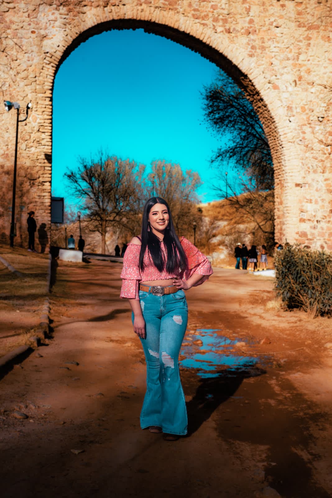 Retrato bajo un arco de cantera con cielo azul