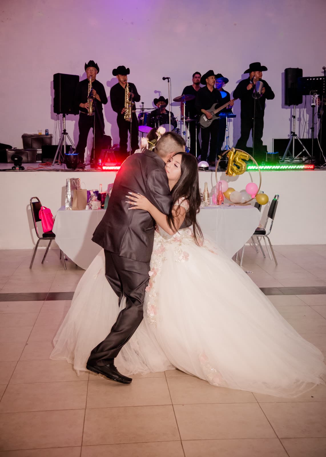 Quinceañera con vestido blanco al centro de la pista